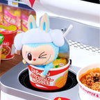 Lamb-shaped container with noodles on a stove, featuring a toy figure and promotional text.